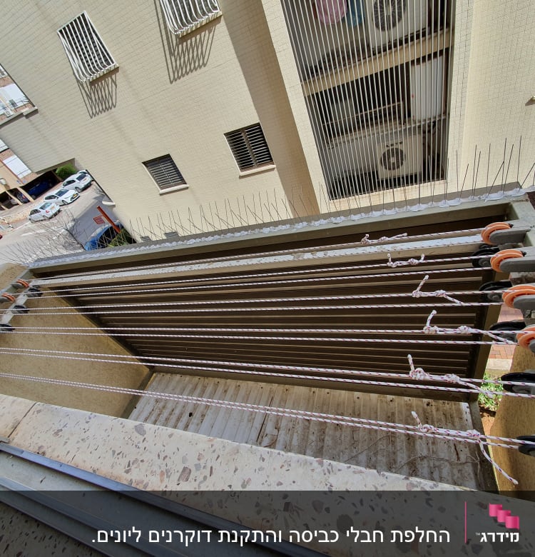 חבלי כביסה עם גלגלות על מרפסת בניין